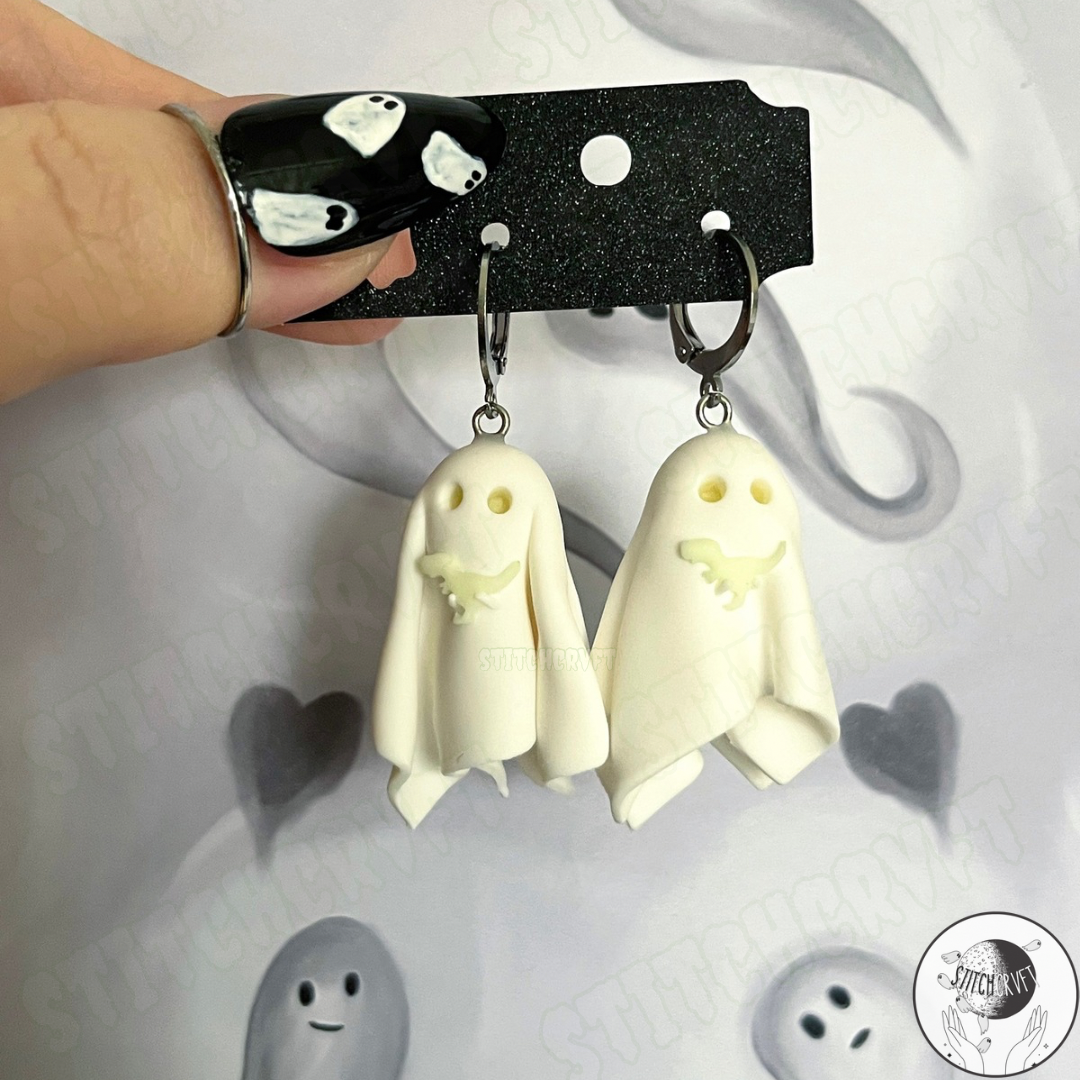 Sheet ghost earrings holding tiny glowing trex with glowing eyes | Handmade to order